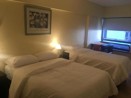 Una habitación de hotel con dos camas y una ventana. en Rancho Porteño, en Buenos Aires