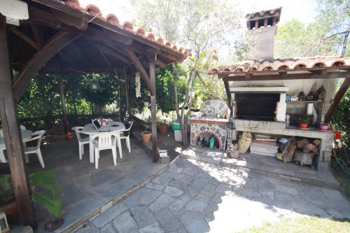 an outdoor patio with a fireplace and a table at Villa Angela in Vourvourou