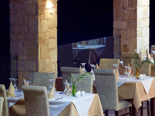 a group of tables with white table cloths and chairs at Filion Suites Resort & Spa in Balíon