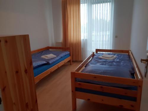 Un dormitorio con dos camas y una ventana. en Blue House, en Győrzámoly
