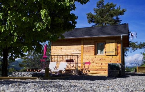 a log cabin with chairs and a table at Clos Shambhala-Chalet d'hôtes in Saint-Jean-Saint-Nicolas