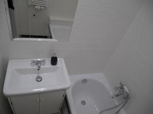 a white bathroom with a sink and a toilet at Moskevská 40 in Karlovy Vary