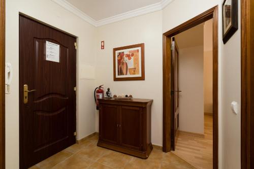 a hallway with a wooden door and a small table at Cozy Apartment PORTIMÃO City Center in Portimão
