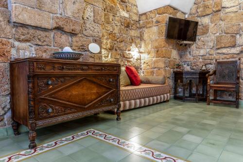 a living room with a couch and a tv at Arabesque Arts & Residency in ‘Akko