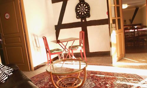 a room with two chairs and a table and a clock at Le gîte des écureuils in Schalkendorf