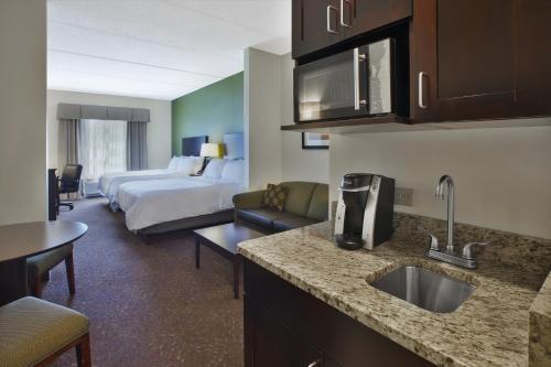a hotel room with a kitchen and a bedroom at Holiday Inn Express & Suites Geneva Finger Lakes by IHG in Geneva