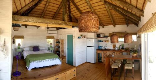 1 dormitorio con 1 cama y cocina con mesa en Casa Papaya, en Punta del Diablo
