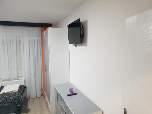 a room with a table and a tv on the wall at Guest House deluxe in Orašje