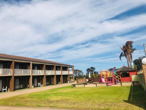 a school building with a playground in the yard at Black Swan Motor Inn in Lakes Entrance