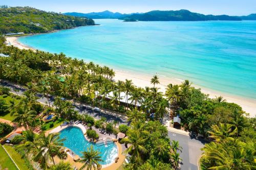 una vista aérea de una playa con palmeras y una piscina en Beachfront Hamilton Island, en Hamilton Island