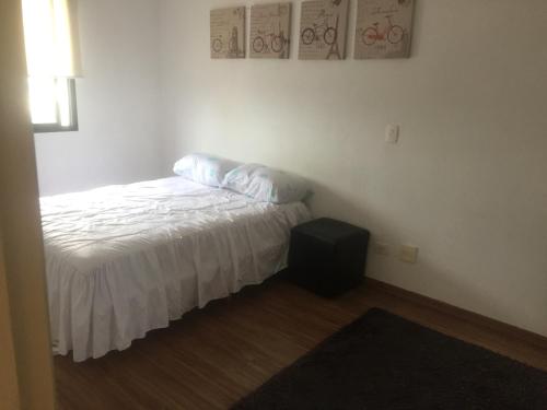 Dormitorio pequeño con cama y mesa en Condominio Jardim Guedala, en São Paulo