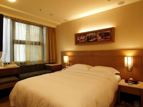 a hotel room with a large bed and a couch at 東鑫商務旅館Eastern Star Hotel in Taipei