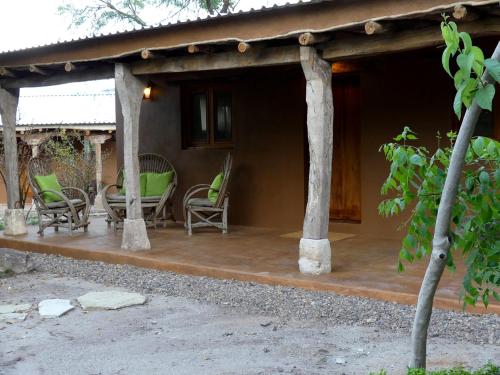 a porch of a house with rocking chairs at El Pedregal - Hotel en la Naturaleza in Álamos