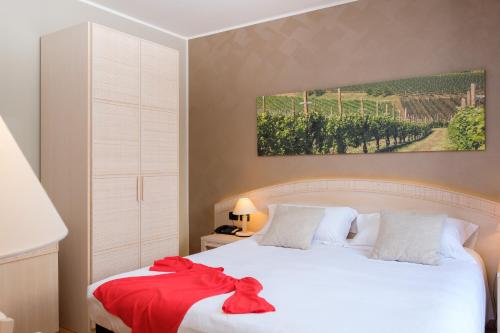 a bedroom with a white bed with a red blanket at Wine Hotel San Giacomo Activity & Wellness in Paderno del Grappa