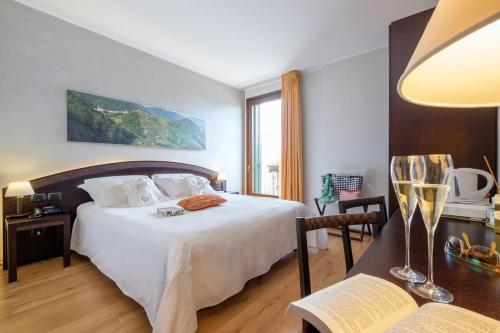ein Schlafzimmer mit einem Bett und einem Tisch mit einem Stuhl in der Unterkunft Wine Hotel San Giacomo Activity & Wellness in Paderno del Grappa