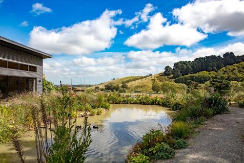 a pond in a garden next to a house at Ballymoney Cnoc in Tai Tapu