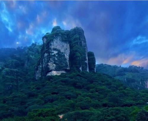 a large rock formation on top of a mountain at Hospedaje San Antonio Tepoztlán. in Tepoztlán