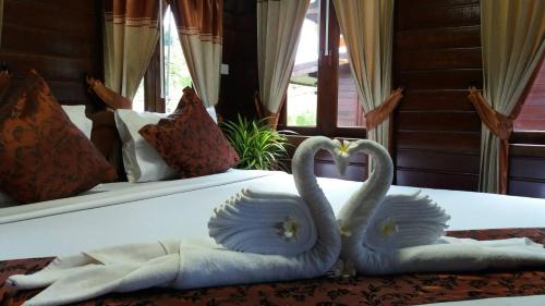 two swans sitting on top of a bed at Baannai Lake View Resort in Ao Nang Beach