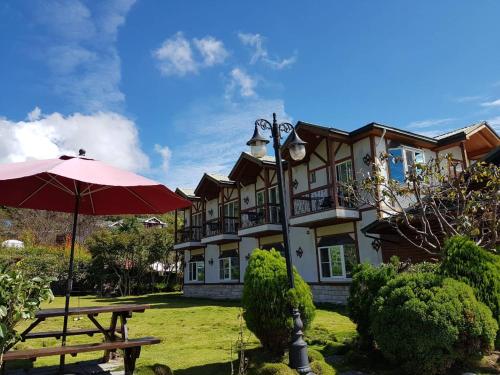 a building with a picnic table and an umbrella at StarVilla in Renai