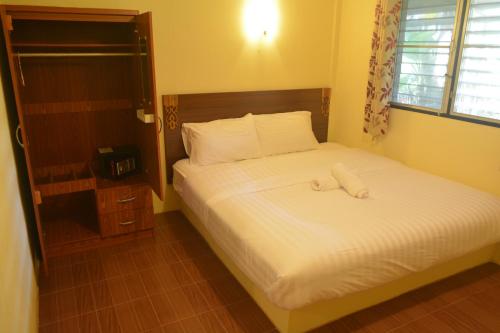 a bedroom with a bed with white sheets and a window at M&M Guesthouse in Ko Chang