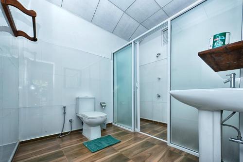 a bathroom with a shower and a toilet and a sink at Jays Holiday Resort in Habarana