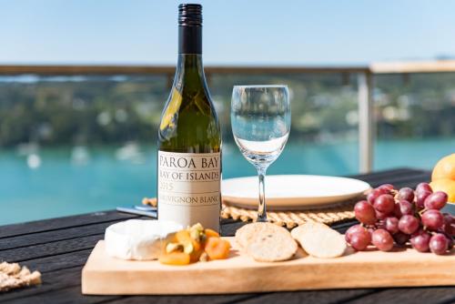 a bottle of wine and a glass on a table at Marina Cove Bay of Islands in Opua