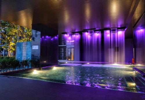 a house with a swimming pool with purple lights at Expressionz Suites By iHost Global in Kuala Lumpur