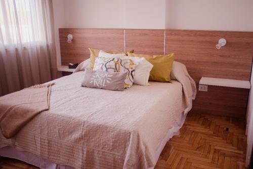 1 dormitorio con 1 cama grande y cabecero de madera en Departamento temporal Colon 401 en Córdoba