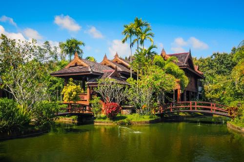 a bridge over a pond in front of a house at Rommai Villa Chiang Rai in Ban Pa Sang (1)