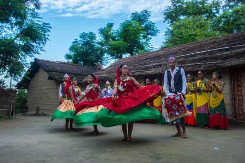 a group of people dressed in costumes in front of a building at Bardiya Community Homestay in Bardia