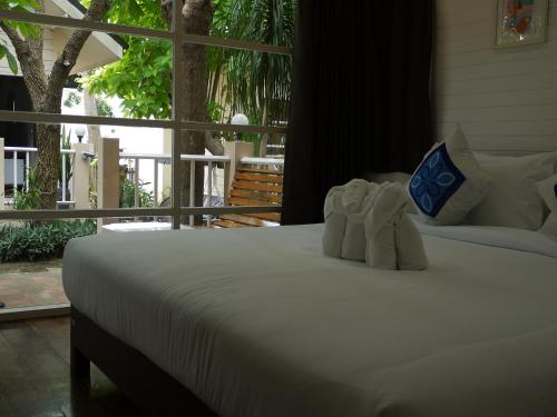 a bed with two white towels on top of it at Reera Resort in Hua Hin