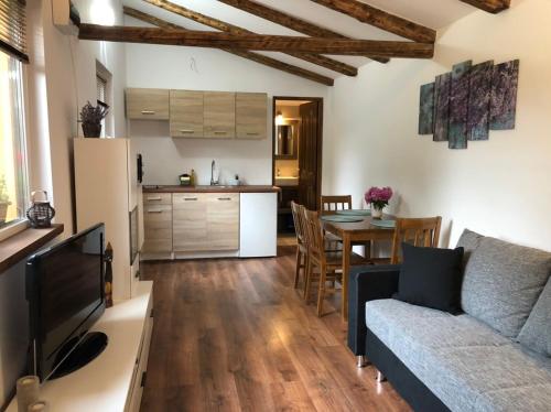 Il dispose d'une cuisine et d'un salon avec un canapé et une table. dans l'établissement Tulipán-Apartman, à Eger