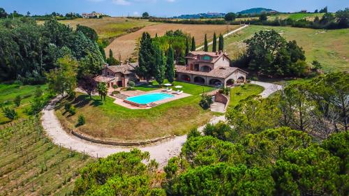 an aerial view of a house with a swimming pool on a hill at Miataland in Collazzone