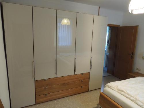 a bedroom with a large white cabinet and a bed at Villa Anna in Bad Gastein