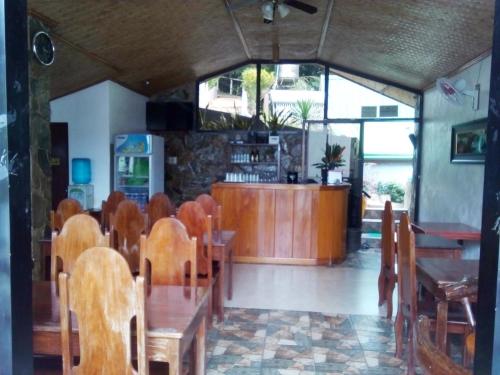 um restaurante com mesas e cadeiras de madeira e um balcão em El Nido Viewdeck Cottages em El Nido