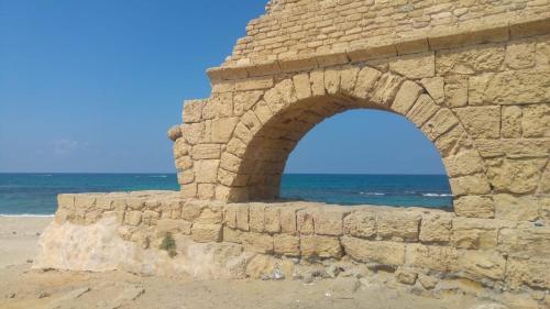 a stone wall on the beach near the ocean at Liz suite in Caesarea