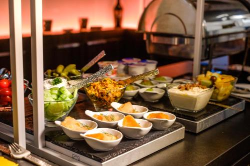 a buffet with bowls of food on a table at Nikii Boutique Hotel in Leverkusen