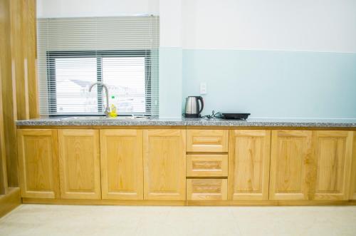 a kitchen with wooden cabinets and a sink and a window at The MONDAY APARTMENT in Ho Chi Minh City