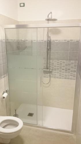 a bathroom with a glass shower with a toilet at B&B Happy Guest in Caprino Veronese