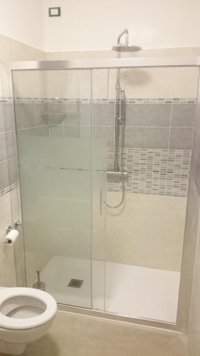 Un baño con ducha de cristal con inodoro. en B&B Happy Guest, en Caprino Veronese
