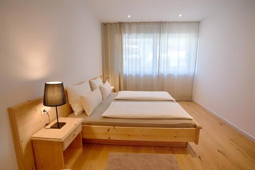 ラーチェスにあるFerienwohnungen Grafwiesenの小さなベッドルーム(ベッド1台、ランプ付)