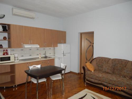 a kitchen and a living room with a couch and a table at Apartament la casa (2 camere) in Timişoara