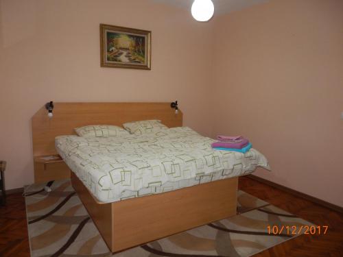a bedroom with a bed with a wooden head board at Apartament la casa (2 camere) in Timişoara