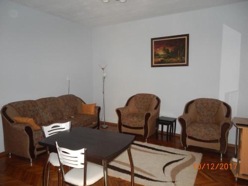 a living room with two couches and a table and chairs at Apartament la casa (2 camere) in Timişoara