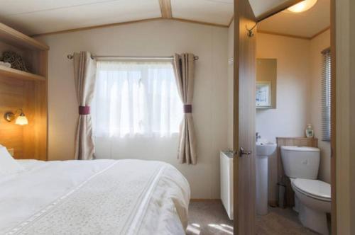 una camera con letto, servizi igienici e finestra di Blenheim, Padstow a Padstow