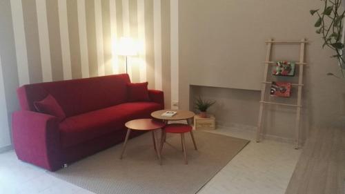 un soggiorno con divano rosso e tavolo di Profumo di Mora guesthouse a Torre del Greco