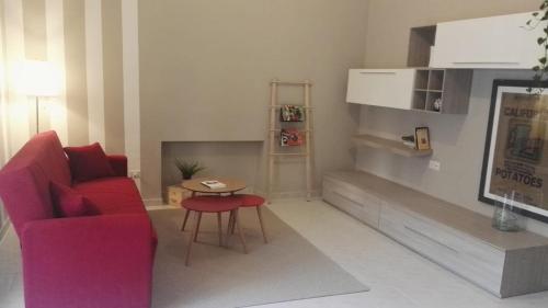 un soggiorno con divano rosso e tavolo di Profumo di Mora guesthouse a Torre del Greco