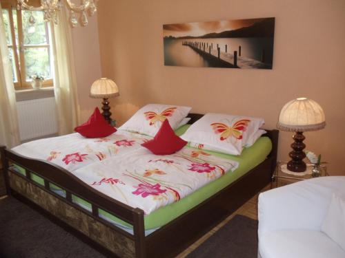 a bed with red and white pillows on it at Haus Martina in Siegsdorf