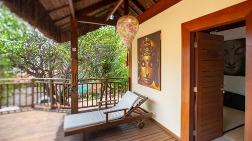 a porch with a bench and a painting on the wall at Sombra e Água Fresca Floresta in Pipa