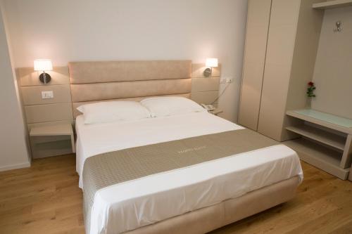 a bedroom with a large white bed with two pillows at Boutique Hotel Enia in Prato